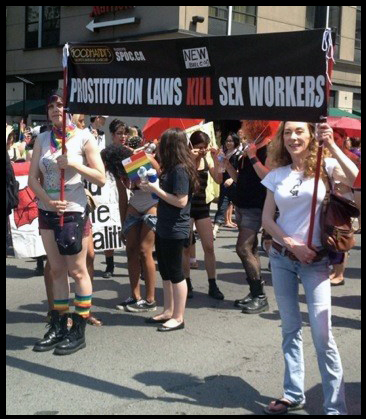Dyke March photo with sign "Prostitution laws kill sex workers"